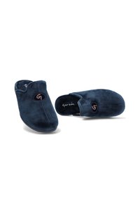 Zapatillas de casa en azul marino, de tela suave, con puntera redondeada, costuras sutiles y un logotipo bordado en el costado.