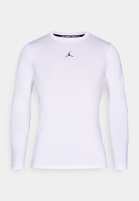 Hvit, langermet, tettsittende treningsskjorte med rund hals og liten svart Jumpman-logo midt på brystet.
