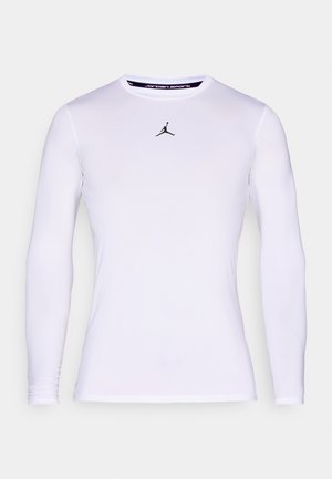 Biela priliehavá športová košeľa s dlhým rukávom, okrúhlym výstrihom a malým čiernym logom Jumpman uprostred hrude.
