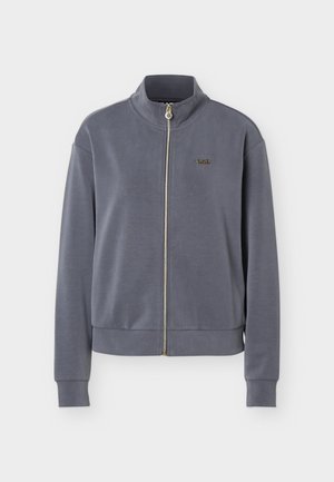 Jachetă gri cu fermoar, guler tip stand, mâneci lungi, manșete drepte și un mic logo brodat pe pieptul stâng.