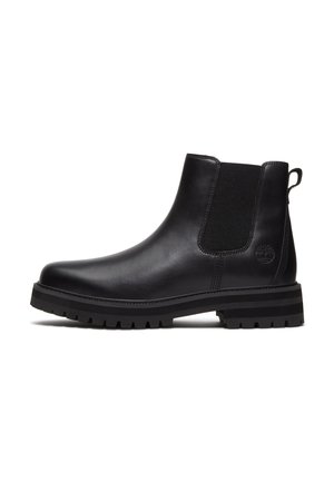 Boots en cuir noir avec panneau latéral élastique, languette au talon, bout rond et semelle épaisse à crampons. Logo Timberland embossé près du talon.