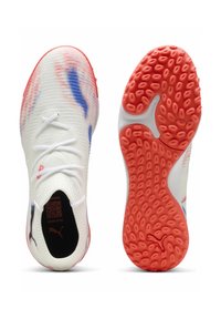 Valkoiset urheilukengät, joissa on tekstuuri päällinen, siniset ja punaiset korostuskuviot, ohuet nauhat ja teksturoitu oranssi pohja, jossa on pyöreät urat.