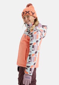 Giacca invernale Roxy color corallo con motivi geometrici multicolori sulle maniche. Accompagnata da un berretto coordinato e guanti.