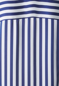 Tessuto a strisce blu e bianche con strisce orizzontali e verticali, caratterizzato da una texture plissettata nella parte inferiore. Materiale liscio e leggero.