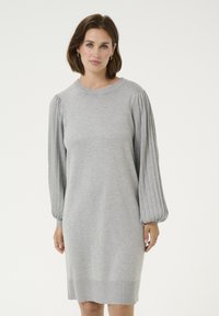 Sivá pletená šaty s uvo ľneným strihom, ktoré majú rebrované, vyp puffové rukávy a okrúhly výstrih, končiace tesne nad kolenom.
