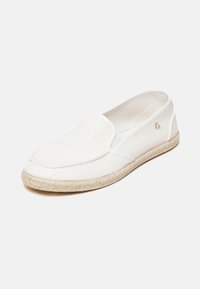 Scarpa slip-on bianca in tela con punta rotonda, suola in juta in stile espadrillas e cuciture minime. Presenta un piccolo logo sul lato.