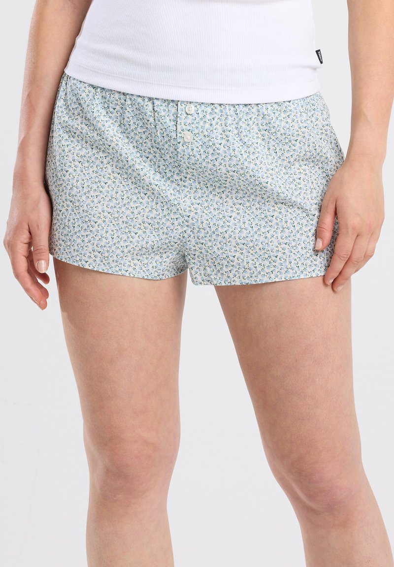 Boxers bleu clair avec un petit motif floral, ceinture élastique et deux boutons à l'avant. Fabriqués en tissu doux.