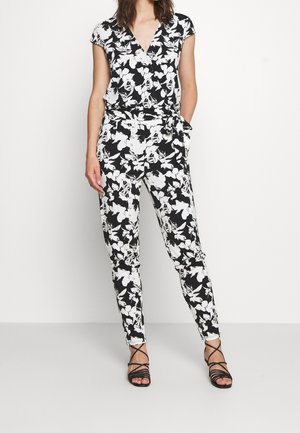 Czarnobiały strój w kwiatowy wzór z kopertową bluzką, krótkimi rękawami i zwężanymi spodniami z wiązaniem w talii. Teksturowana tkanina, casualowy design.