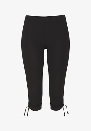 Melnas īsas legingu bikses, kas izgatavotas no mīksta, elastīga auduma ar saliektiem volāniem apakšmalā un regulējamu saiti pie potītiem.