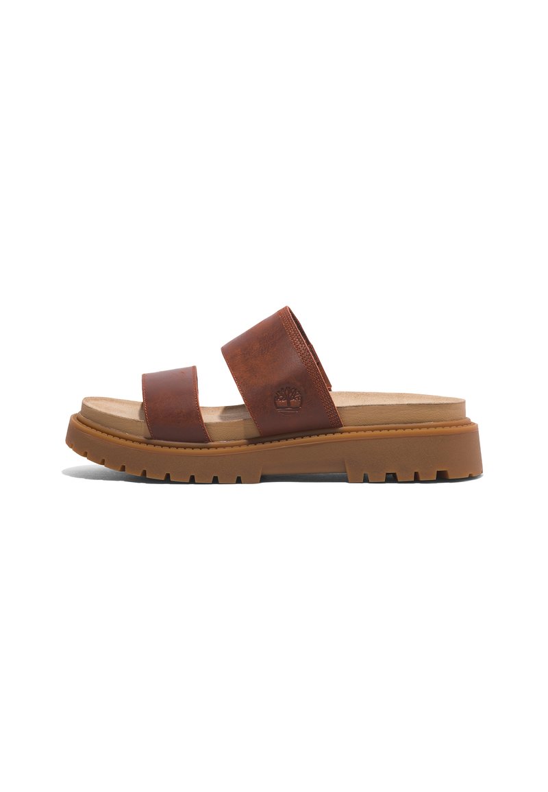 Brown leather slide sandals with two wide straps, a cushioned footbed, and a grooved rubber sole for traction. Timberland logo embossed.