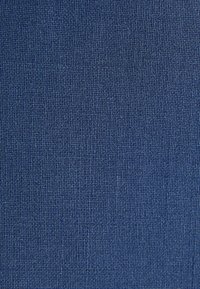Close-up of tightly woven blue fabric with a fine, grid-like texture and subtle variations in shading.