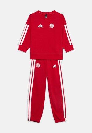 Ensemble haut à manches longues rouge et pantalon avec bandes blanches Adidas et logos du FC Bayern Munich sur la poitrine et la cuisse.