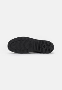 Talpa de sneaker negru cu un model de textură. Include caneluri și accente ridicate pentru aderentă. Margini netede și o zonă întărită pentru călcâi.