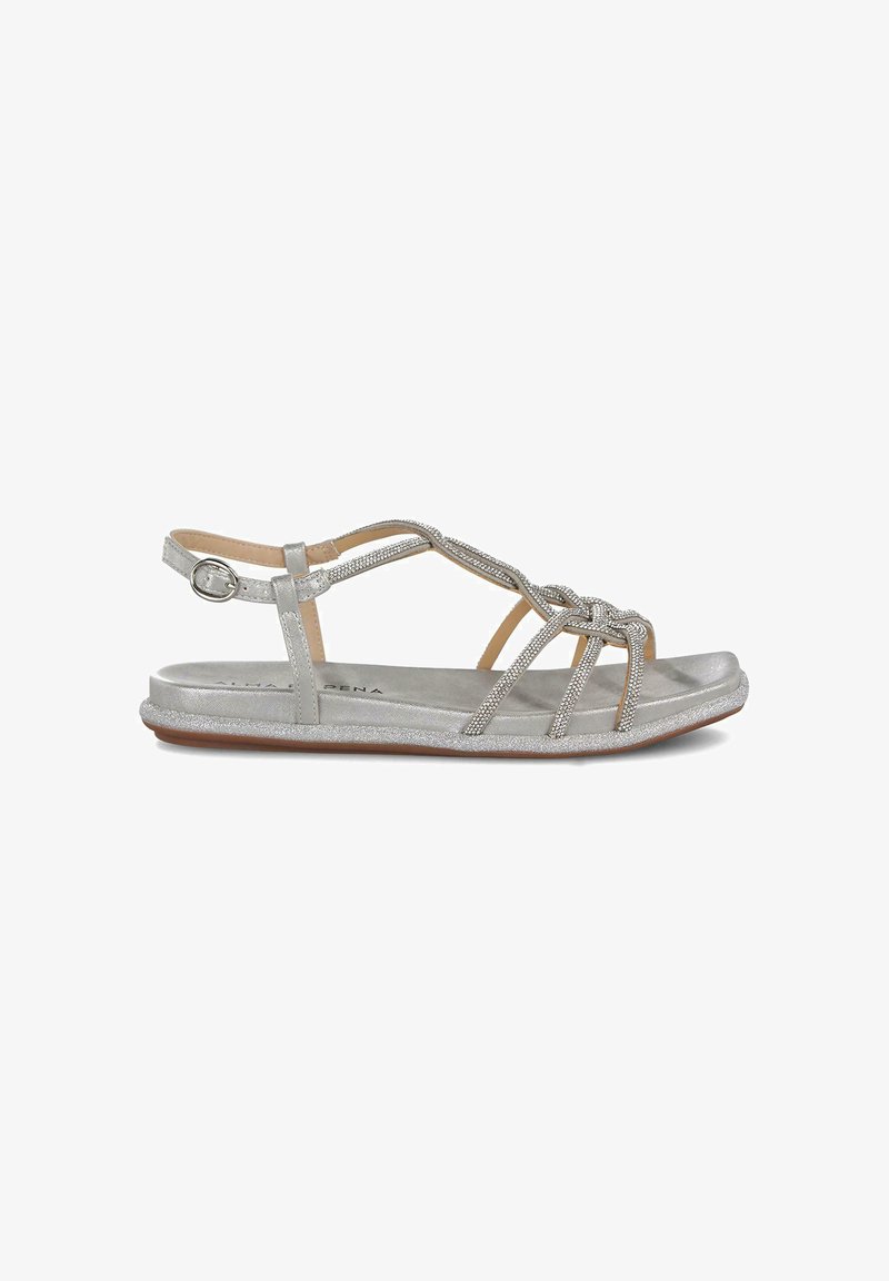 Sandalia plateada con tiras entrelazadas y acentos brillantes. La suela plana presenta un acabado texturizado. Hebilla ajustable para un ajuste seguro.