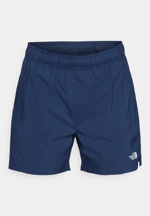 Tamsiai mėlyni šortai iš lengvos medžiagos, su elastinga juosmens juosta, šoninėmis kišenėmis ir balta logotipu apatinėje briaunoje.