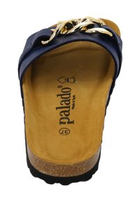 Donkerblauwe sandaal met een dikke zwarte zool, gouden kettingaccent op de band en een kurken voetbed. Merkenlogo zichtbaar op de binnenzool.