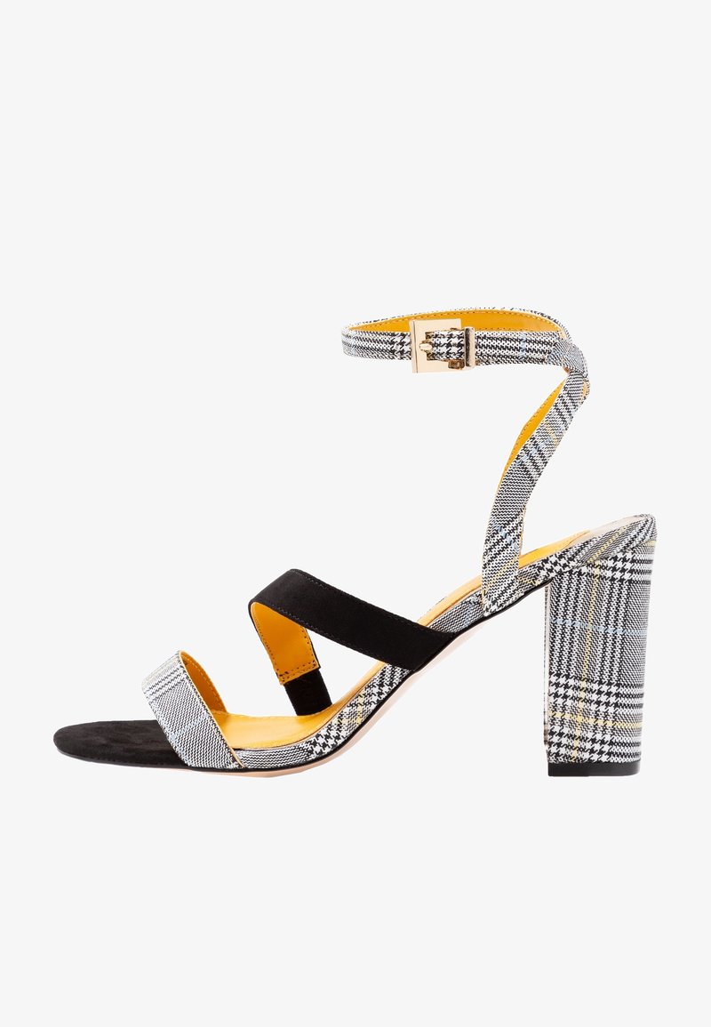 Klack sandalett med ovandel i svart mocka och mönstrad tyg i grått och vitt. Tjock klack, gul inredning och justerbar vristrem.