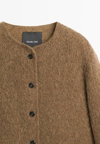 Brązowy wełniany kardigan o fakturowanej powierzchni, z okrągłym dekoltem i trzema czarnymi guzikami, wewnątrz z metką "Massimo Dutti".