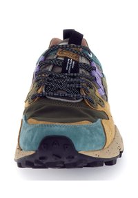 Scarpa da trekking multicolore con lacci bianchi e neri, punta in suede blu, suola beige con battistrada nero e dettagli laterali viola, vista frontale.