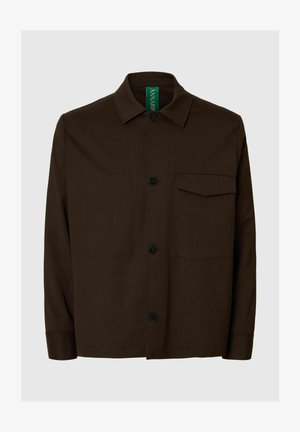 Bruine jasje met knoopsluiting, gemaakt van gestructureerde stof. Heeft een puntige kraag, een borstzak aan de voorkant en zwarte knopen. Groene merklabel aan de binnenkant.