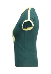 Camiseta de algodón verde con detalles de color amarillo en las mangas y el cuello, que presenta un corte informal y un dobladillo redondeado en la parte inferior.