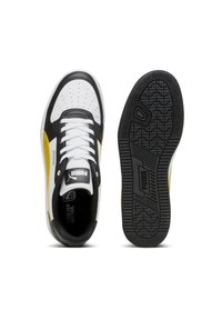 Černobílé tenisky s žlutými akcenty, mají perforovanou špičku, texturovanou podrážku a kontrastní tkaničky. Logo značky na jazyku.