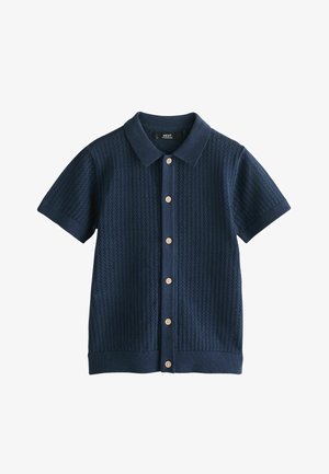 Lühikeste varrukatega mereväe sinine kootud polo, millel on tekstuuriga muster, nööpidega esikinnitus ning soonikuga krae ja ääred.