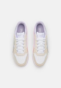 Sneakers con una morbida tomaia in pelle beige, accenti bianchi e suola in gomma colorata. Le caratteristiche includono punta rotonda, design con lacci e dettagli perforati.