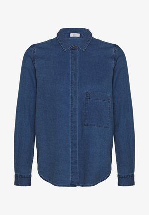 Chemise en denim bleu foncé à manches longues, avec fermeture à boutons sur le devant et une poche poitrine. Dotée d'un col et d'un ourlet arrondi.