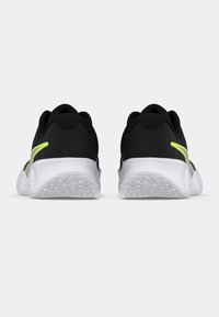 Μαύρα αθλητικά παπούτσια με υφή στο υλικό, διαθέτουν λευκή σόλα και φωτεινή κίτρινη λεπτομέρεια στο πλάι. Διπλός σχεδιασμός στη φτέρνα για σταθερότητα.
