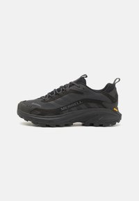 Black trail running shoes featuring a mesh upper, rugged rubber sole, and Gore-Tex support. Includes a pull tab and textured accents.