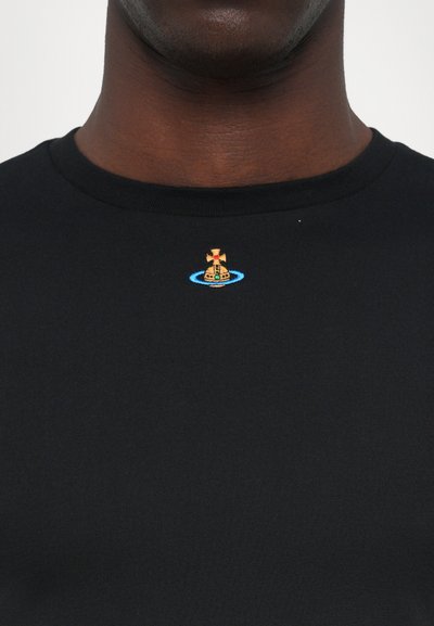 Tricou negru din bumbac cu guler rotund, având un mic design brodat cu o cruce pe un vehicul într-un cerc albastru.