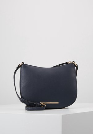 Navy leren schoudertas met een gladde textuur, gebogen silhouet, verstelbare schouderband en hardwareaccenten in goudkleur.