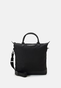 Svart nylon tote-väska med dubbla handtag, justerbar axelrem och dragkedjeslutning. Har en slät yta och en minimalistisk design.