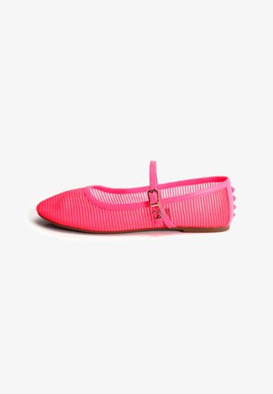 Zapato plano de punta puntiaguda de color rosa brillante, con tela translúcida a rayas, correa en el tobillo con hebilla y tachuelas en el tacón, exhibido sobre un fondo blanco.