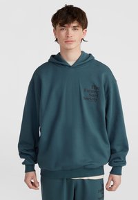 Teal prevelik hoodie iz mehkega blaga, z kenguru žepom, rebrastimi manšetami in grafiko besedila na levem prsnem delu.