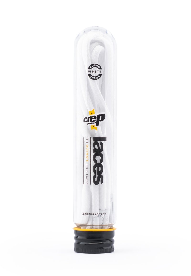 Stringhe bianche tonde per scarpe confezionate in un tubo di plastica trasparente con una base nera e gialla. Presentano il logo del marchio e dettagli del prodotto sul tubo.