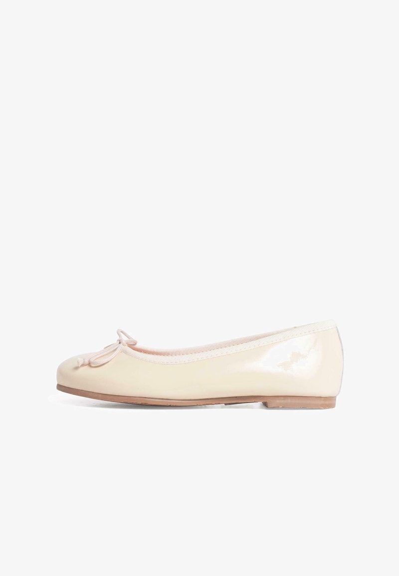 Ballerine couleur crème avec un petit nœud à l’avant et une semelle plate en bois, vue de côté sur fond blanc.