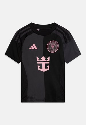 T-shirt de sport noir et rose avec un design divisé, un logo en tissu, un col rond et trois rayures sur les épaules. Matière légère et texturée.