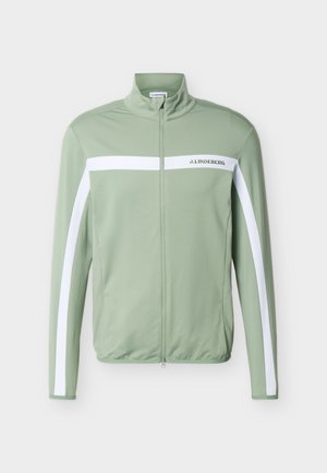 Ανοιχτό πράσινο ζακέτα με φερμουάρ, με λευκές οριζόντιες και κάθετες ρίγες και το κείμενο "J. Lindeberg" στο στήθος.