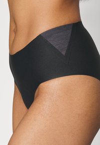 Black high-waisted underwear with a smooth texture and triangular gray panel at the waist. Features a seamless design for comfort.
