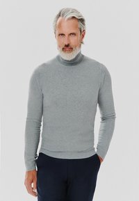 Szary sweter z golfem, wykonany z miękkiej dzianiny, dopasowany krój, z długimi rękawami i ściągaczem u dołu, noszony z ciemnymi spodniami.