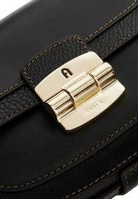 Zwarte leren tas met een goudkleurige sluiting met een verhoogde "A" en het geëmbosseerde "Furla" logo. Geweven leer met contrasterende stiksels.