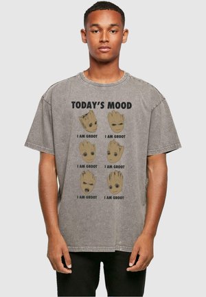 Graues, übergroßes T-Shirt mit einem Grafikdruck, der sechs Darstellungen von Groots Gesicht zeigt, darüber in fetten Buchstaben den Text "HEUTIGE STIMMUNG".