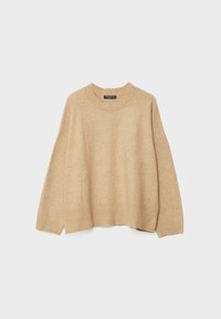 Pull beige en laine à col rond avec manches longues et poignets et ourlet côtelés, présenté sur un fond gris clair uni.