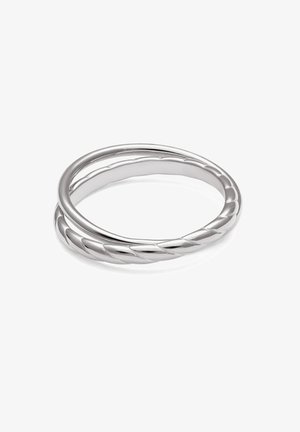 Dos anillos de plata entrelazados, uno con acabado liso y el otro con un diseño retorcido, exhibidos sobre un fondo blanco.