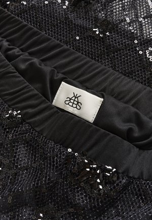 Black sequined fabric featuring a textured mesh design and a smooth satin waistband with a white label. The overall appearance is glossy.