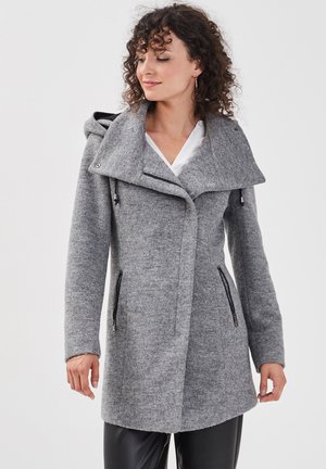 Manteau en mélange de laine gris avec capuche, col asymétrique, poches zippées à l'avant et finition texturée. Manches longues et silhouette cintrée.