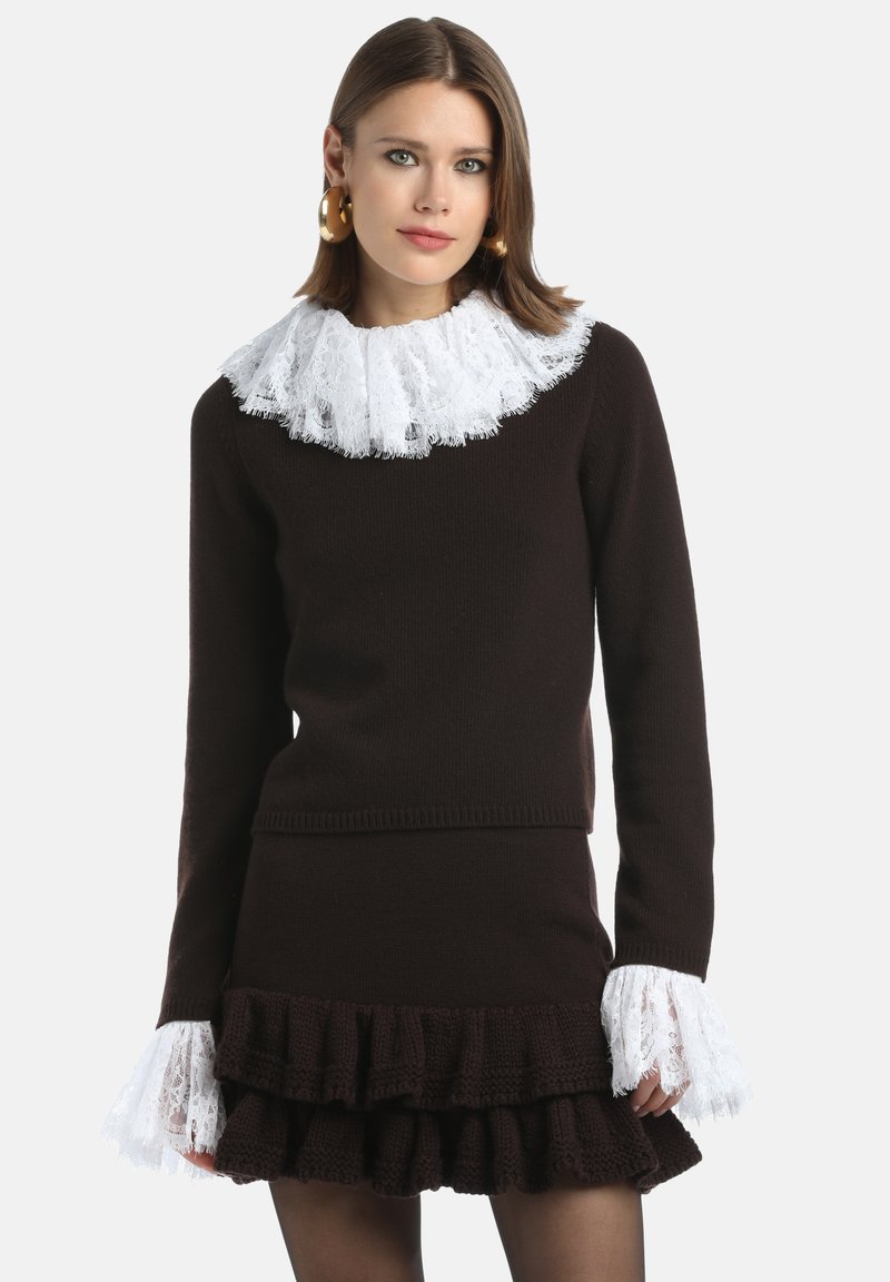 Ensemble en tricot marron comprenant un pull et une jupe, avec un col en dentelle blanche et des manches à finition en dentelle, présentant un ourlet à volants en plusieurs niveaux.