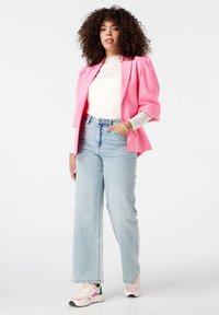 Roze blazer met pofmouwen, witte kanten top, lichtblauwe wijduitlopende spijkerbroek en meerkleurige sneakers. Eenvoudige accessoires zijn inbegrepen.